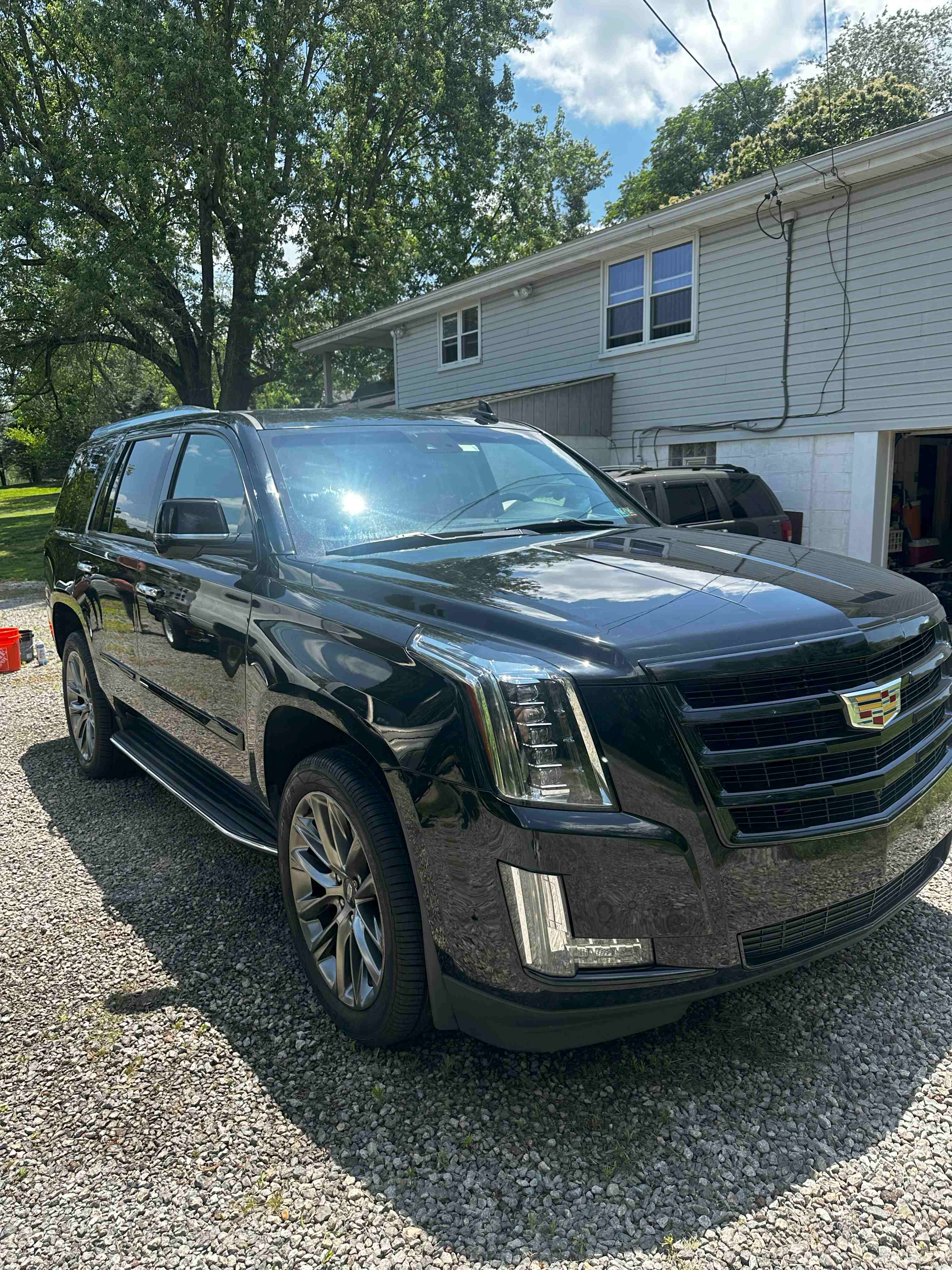 Black Cadillac Escalade with mirror-like finish showcasing luxury SUV detailing